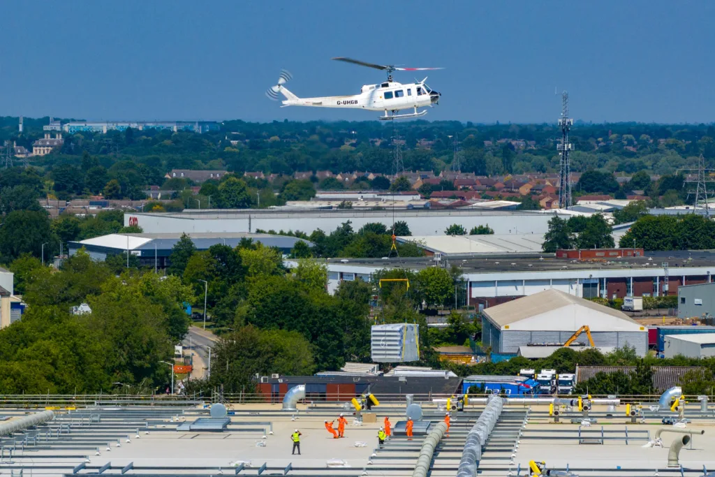 A 625,000ft sq ft factory complex under construction in Peterborough is using a Bell 205A-1 Helicopter (Helilift Services) to move construction materials to the roof of the massive factory.,Delta Park, Peterborough
Saturday 10 June 2023. 
Picture by Terry Harris.