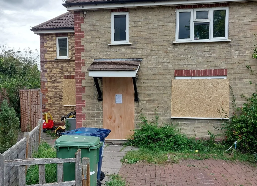 Sgt Kevin Sutcliffe fixes the closure order to the front of 9 Queens Meadow, Cambridge 