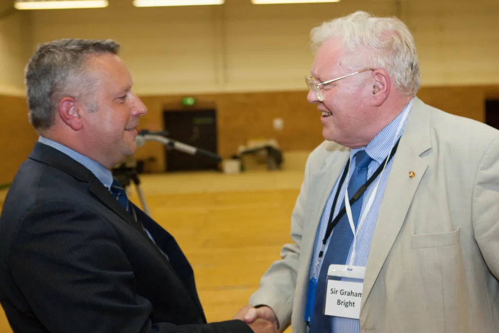 Sir Graham Bright (right) congratulating his successor Jason Ablewhite as police and crime commissioner for Cambridgeshire PHOTO: Terry Harris 