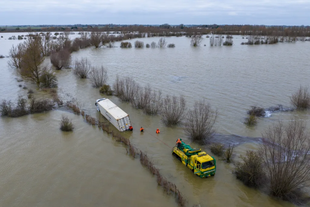 Manchetts staff weighing up the options to rescue lorry and container from flooded A1101 at Welney on the Cambridgeshire/Norfolk border. PHOTO: Terry Harris
