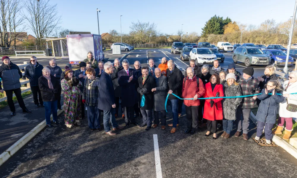 Ribbon-cutting celebration time: Getting ready to officially open Manea Station car park is Dr Nik Johnson, Mayor of Cambridgeshire & Peterborough (centre), with local MP Steve Barclay; Cllr Chris Seaton, Fenland District Council’s Cabinet member for transport and Chairman of the Hereward Community Rail Partnership; Steve Emery, former parish councillor and Hereward Community Rail Partnership board member; Cllr Ben Bonos, Chairman of Manea Parish Council; Jonathan Denby, Head of Corporate Affairs for Greater Anglia; and other partners, board members and representatives involved in bringing the project to fruition.