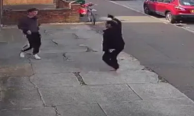 Shortly after being attacked and robbed, a brave shopworker is seen hitting back at her attacker outside her shop. IMAGE: Cambs Police