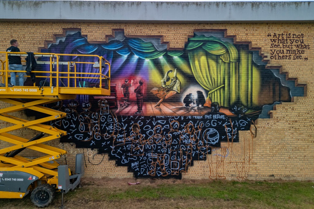 Nathan Murdoch working on a mural on the wall of the Key Theatre, Peterborough.  Embankment, PeterboroughWednesday 08 May 2024. Picture by Terry Harris.