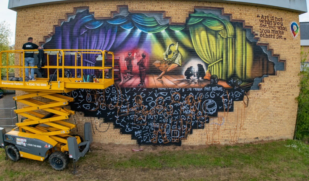 Nathan Murdoch working on a mural on the wall of the Key Theatre, Peterborough.  Embankment, PeterboroughWednesday 08 May 2024. Picture by Terry Harris.