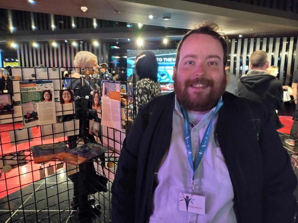 Speak Out leader Bill Jones pictured next to an exhibition at the awards which paid tribute to his sister Elspeth. Photo credit: VoiceAbility