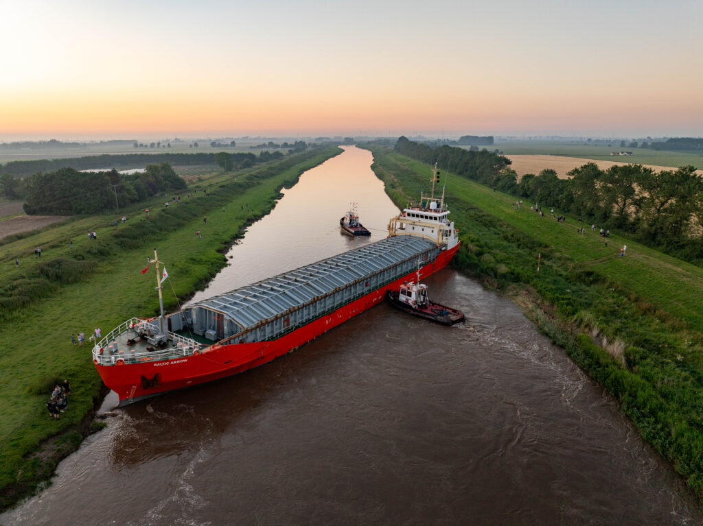 Spectators gathered by the River Nene in Wisbech as the Baltic Arrow, with its cargo of timber from Latvia, was finally freed and pulled into port. PHOTO: Terry Harris 