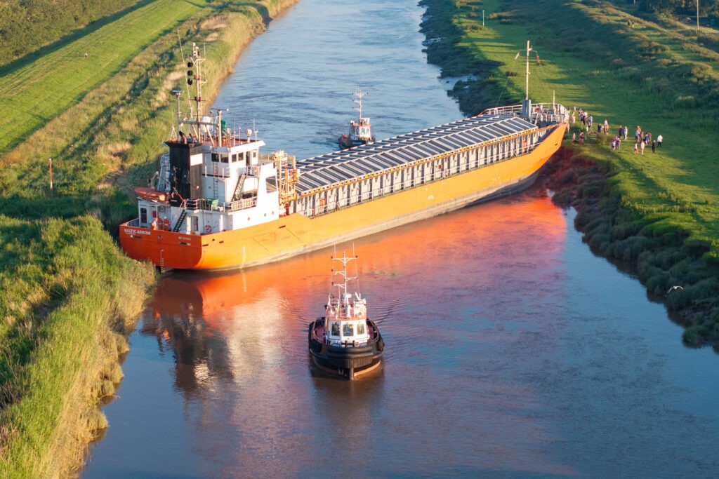 Spectators gathered by the River Nene in Wisbech as the Baltic Arrow, with its cargo of timber from Latvia, was finally freed and pulled into port. PHOTO: Terry Harris 